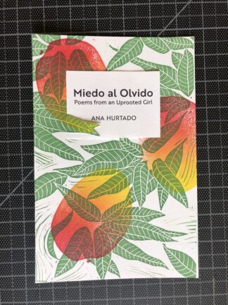 A copy of the chapbook Miedo al Olvido by Ana Hurtado, including multicolored ripe mangos and dark green leaves in a hand-printed linocut pattern, and text in black ink.