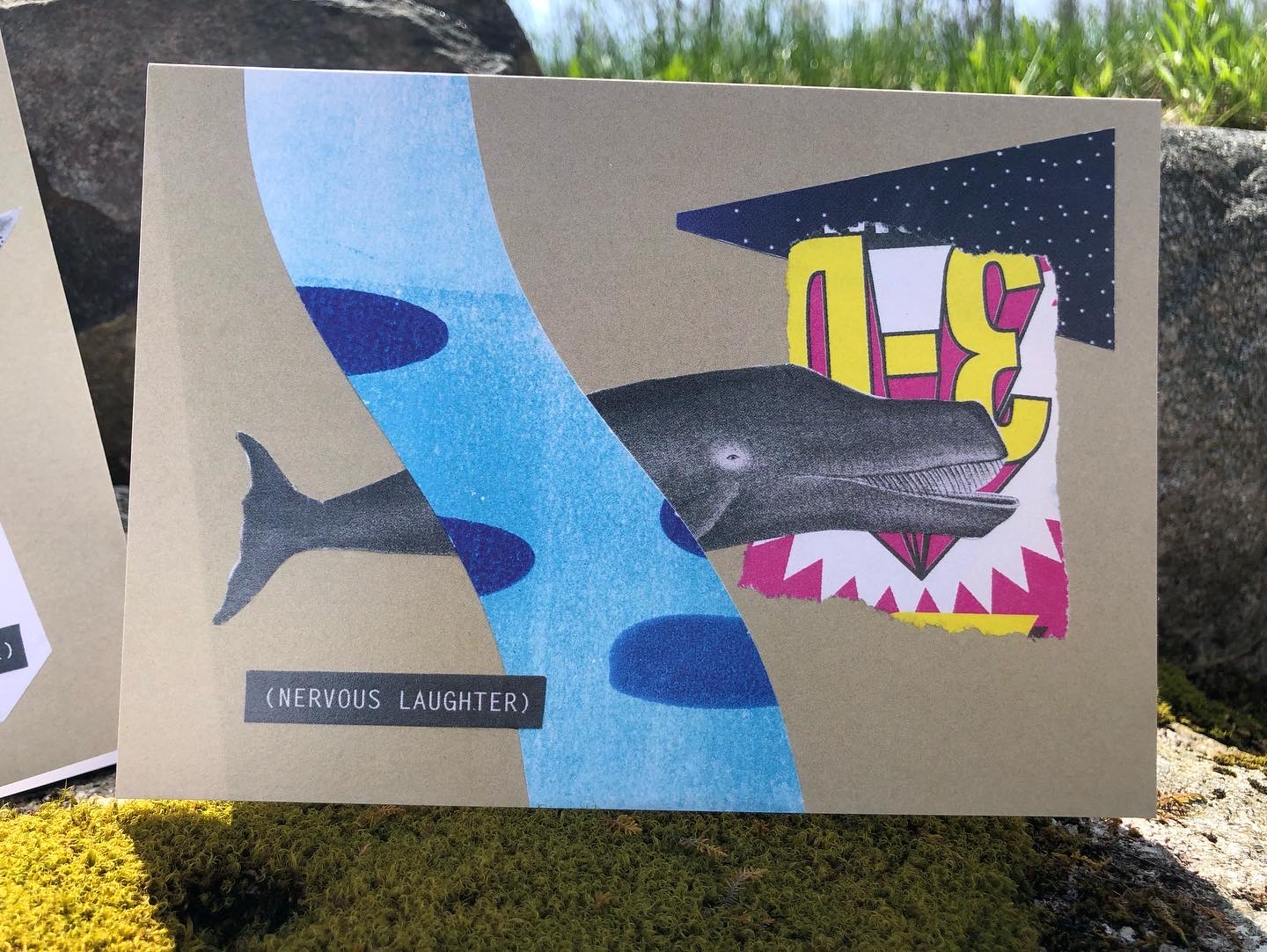 The Nervous Laughter Whale card, standing in the sunlight on a mossy boulder. A black-and-white whale with a big grin swims among cut and torn pieces in bright colors, including a blue wave, night sky with stars, and torn bit from a hot pink and yellow ad for 3D glasses. A closed caption–style title in the lower left says Nervous Laughter in all caps.